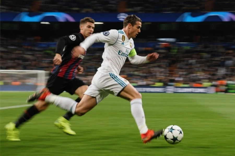 一位足球运动员正在高速带球突破防守，背景是欧洲冠军联赛决赛现场